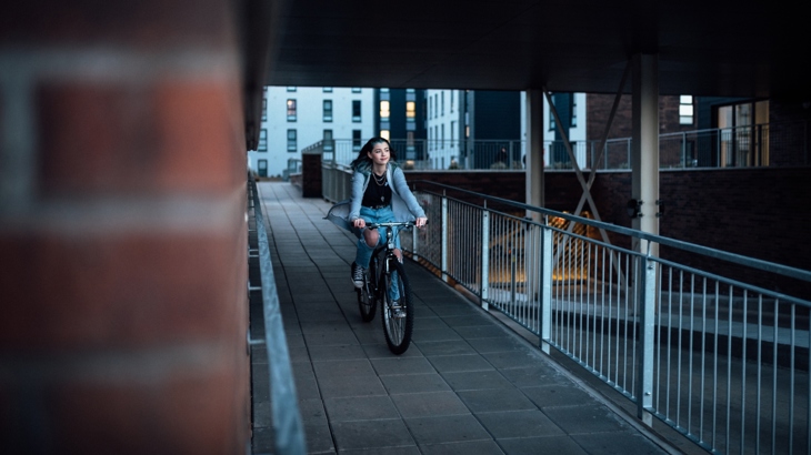 A teenage girl cycles through an underpass for the 'AndSheCycles' video shoot.