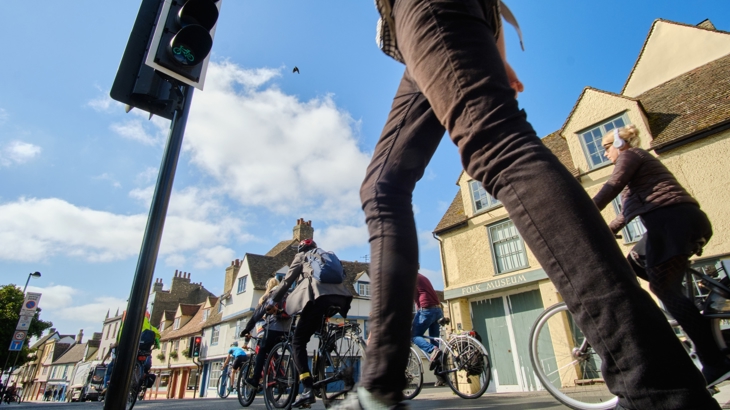 person walking and many people cycling in urban area