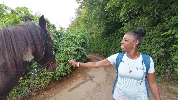 Sophie Brown of Steppin Sistas pets a horse in a country lane.