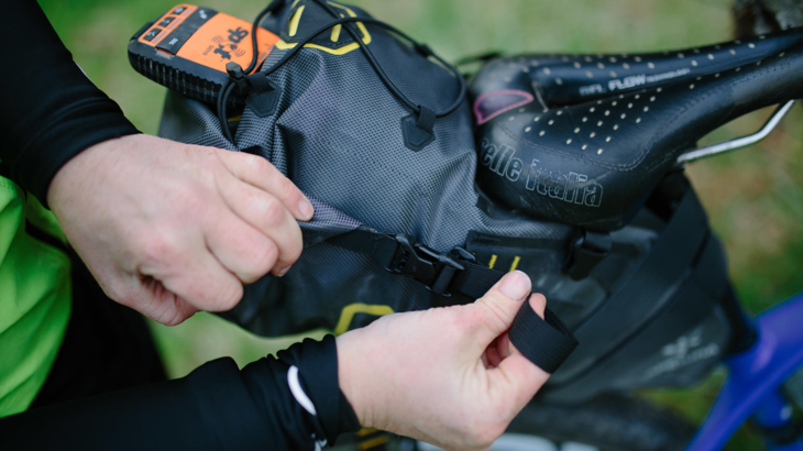 A close up of a person's hand holding a bike bag.
