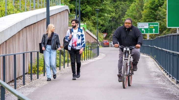 People walking and cycling on a traffic free link at Raigmore in Inverness.