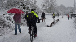 The Bristol Bath Railway Path covered in snow whilst people walk and cycle by