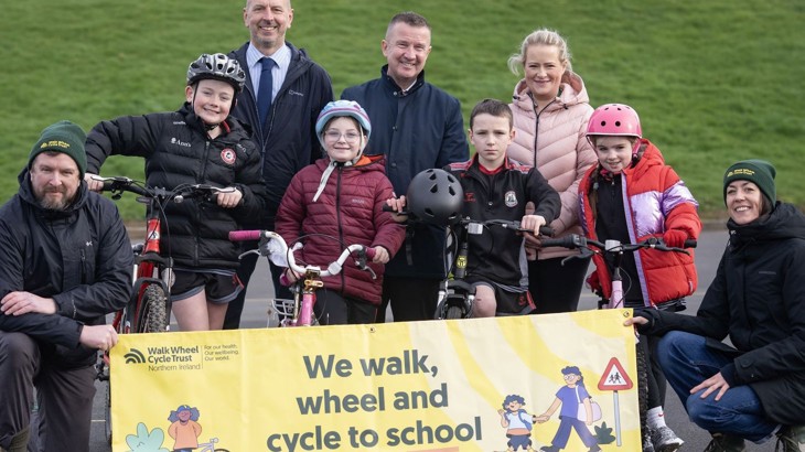 Teachers, pupils and Walk Wheel Cycle Trust colleagues launch Big Walk and Wheel with banner in playground