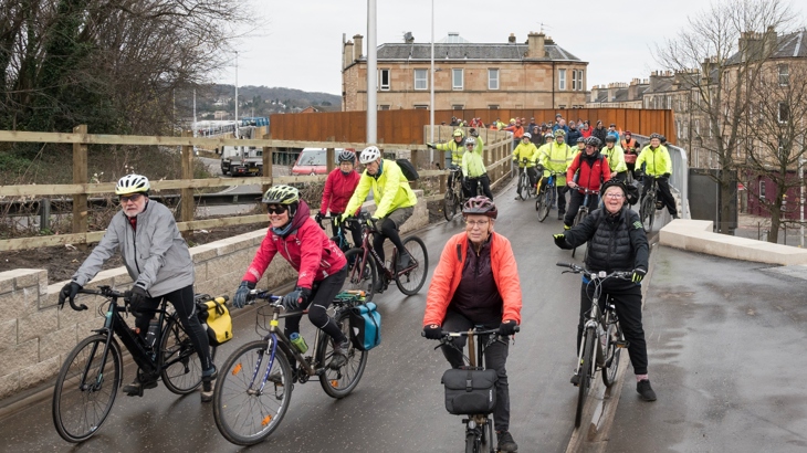 People cycle over the new bridge installed as part of the Roseburn to Union Canal active travel route.