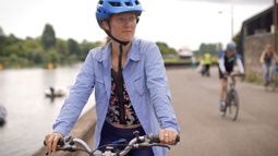 PhD student Veronica White on her bike cycling along the National Cycle Network alongside the River Exe in Exeter.