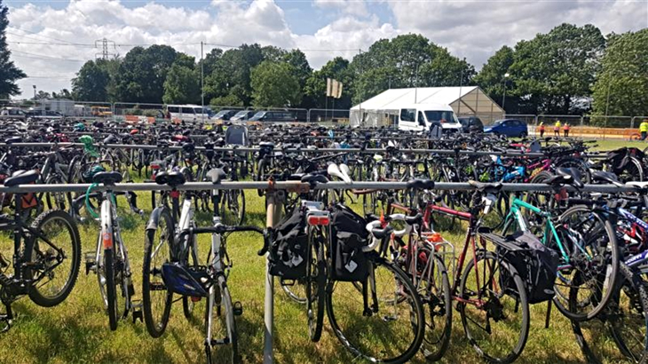 Hundreds of bicycles locked up on the grounds of Glastonbury Festival on an overcast but bright day