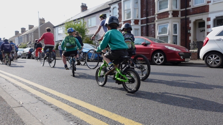 Pupils and adults taking part in a bike bus through Cardiff.